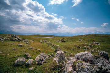 Fototapeta na wymiar Caucasus mountains, Mestia, Svaneti region, Georgia. Summer day, green hills, high mountain pasture for livestock, white Nature and travel. Stones, boulders, rock.