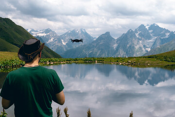 A man use small drone. Drone control, video recording and photography from the air. Unmanned aerial vehicle. Koruldi Lake Reserve. Mountains of the Caucasus. Georgia. Copy space
