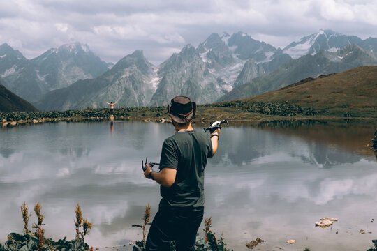 A man catches a small drone on his hand. Drone control, video recording and photography from the air. Unmanned aerial vehicle. Koruldi Lake Reserve. Mountains of the Caucasus. Georgia.