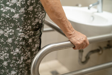 Asian elderly old lady woman patient use toilet bathroom handle security in nursing hospital,...