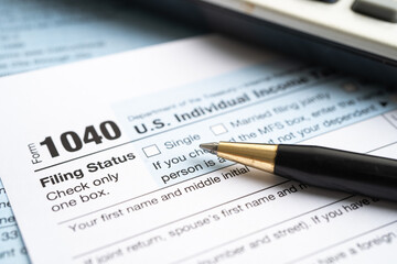 Tax Return form 1040 and dollar banknote, U.S. Individual Income.