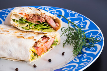 Delicious kebab with meat, lettuce, tomato, onion and sauce with french fries.