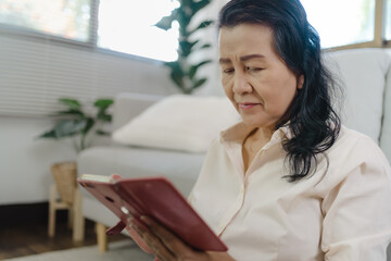 Middle age Asian woman holding cell telephone. senior woman with smart phone. elderly woman using smartphone at home with technology concept.