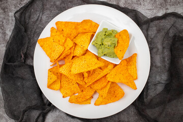 plate of corn chips nachos with guacamole on plate