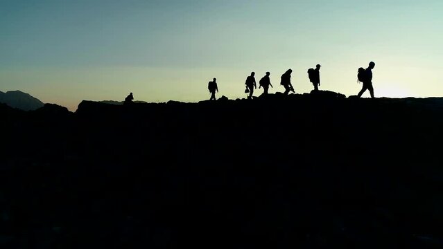 group of mountaineers marching in a row led by a leader