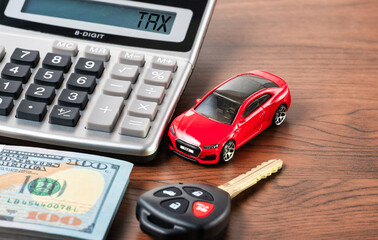 Car tax concept with red car toy, calculator, car key and banknotes on wooden table. 