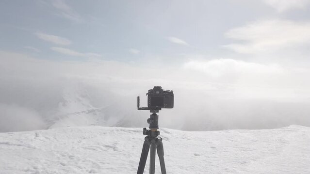 camera on tripod in mountains in blizzard