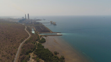 power station with spillway by sea with smoking pipes, paiton java, indonesia. aerial view power...