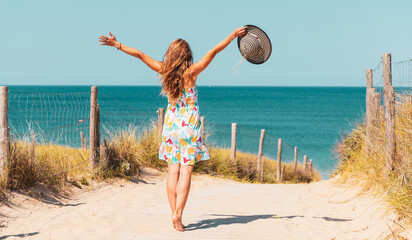 Happy slim woman on beach in summer dress outfit