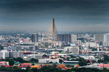 Obraz premium Suspension Rama 8 Bridge with financial building and temple in downtown