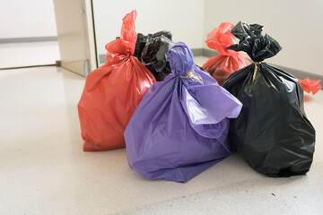 Different waste bag on white floor background,Red, black and purple bags waste on white...