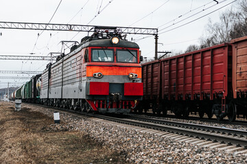 freight trains moving towards each other on a parallel road. cargo transportation by rail. red locomotive
