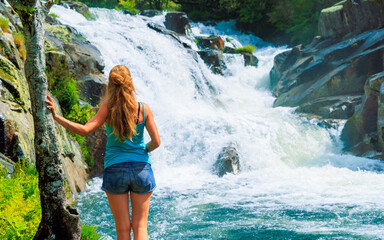beautiful waterfall et rear view of woman enjoying it- Travel in Europe