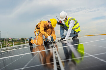 Engineers check the installation of solar panels on the factory roof, command engineers, supervise the installation of solar panels, engineers and technicians check the operation of solar panels.