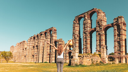 Woman traveling in Spain- Merida city,   Roman bridge aqueduct in Extremadura - obrazy, fototapety, plakaty