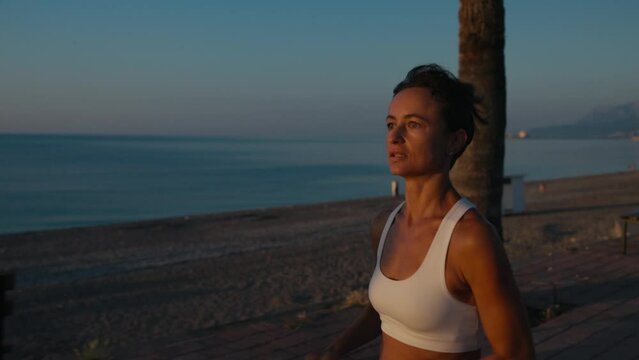Young fitness sport woman running on road at sunset. Athlete runner feet running on road, slow motion. High quality 4k footage