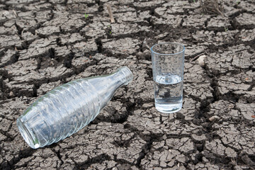 The empty water bottle symbolizes water scarcity, while the half-full glass of drinking water...