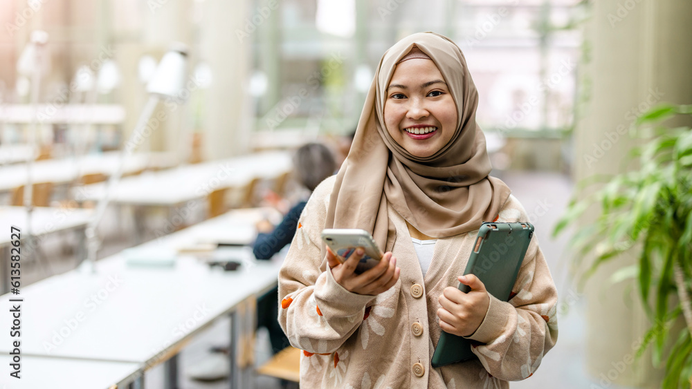 Wall mural Portrait of asian muslim female student in a library
