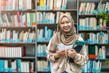 Portrait of asian muslim female student in a library

