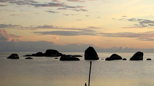 view of the beach in the morning with large rocks