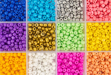 Plastic beads of different colors in separate cells of the container