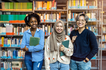 Group of diverse students smiling at camera while standing together in a library