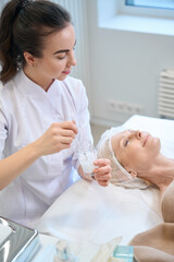 Obraz na płótnie Canvas Female beautician preparing for beauty procedure in cosmetologist office