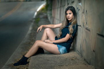 Relaxed urban fashion: serene young woman under stone overpass on city street