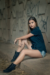 Relaxed urban fashion: serene young woman under stone overpass on city street