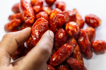 Showing Milagai mittai in hand - White background chilli candy