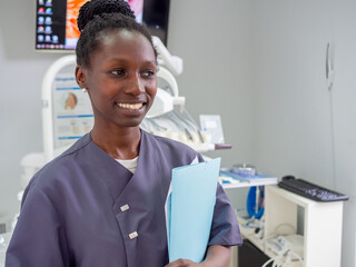 Young female dentist smilling while holding a file