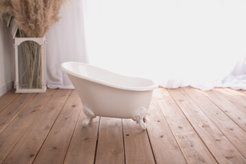 Gorgeous decorative white bathtub for babies in a white background with garland flowers for first...