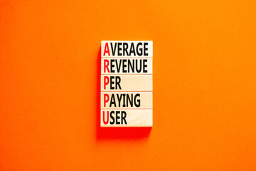 ARPPU average revenue per paying user symbol. Concept words ARPPU average revenue per paying user on wood block. Beautiful orange background. Business ARPPU average revenue per paying user concept.