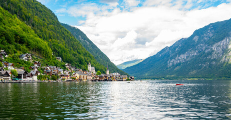 Famous Hallstatt city panorama with typical church near the Hallstatter see. Dramatic clouds on the sky. Famous tourist destination in Austria.