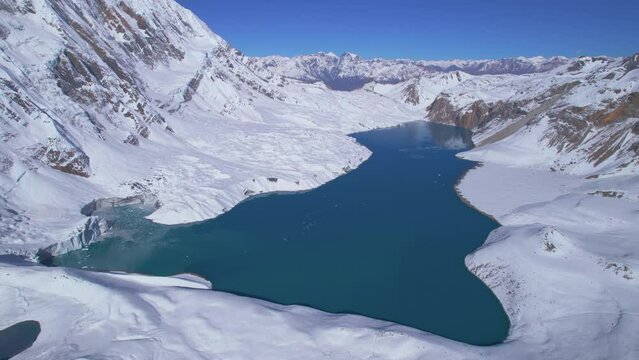 Aerial backwards view spectacular panorama of beautiful blue alpine Tilicho lake and surrounded high Himalayas mountains. Tilicho lake trekking route destination, Manang, Nepal