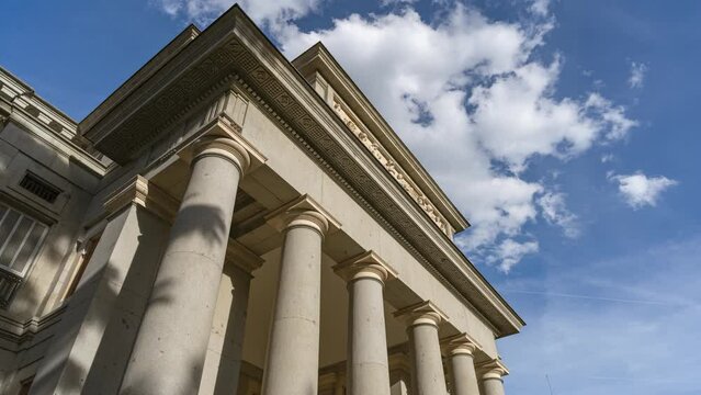 Fachada de gran museo u otro edificio p&uacute;blico  con grandes columnas y el tiempo acelerado con las nubes y las sombras en movimiento.