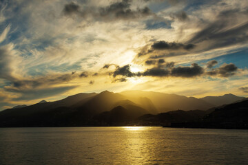 Mountains by the sea at sunset and the city on the shore.