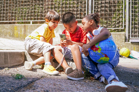 afro latin, asian, and caucasian children learning online together. Happy multiethnic friends studying outside