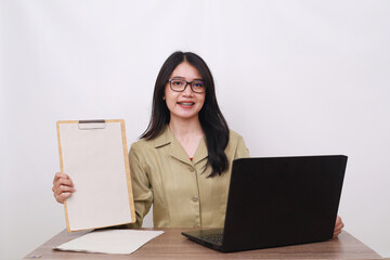 Female teacher in civil servant uniform with paper and laptop on the desk showing blank paper