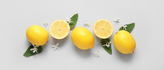 Flowers and lemons on light background, top view