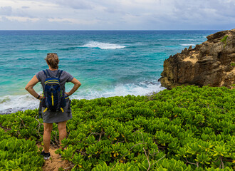 Female Hiker and Makawehi Bluff on The Maha'ulepe Heritage Trail, Kauai, Hawaii, USA © Billy McDonald