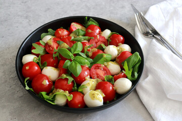 Delicious Italian capers salad with tomatoes, mozzarella and basil