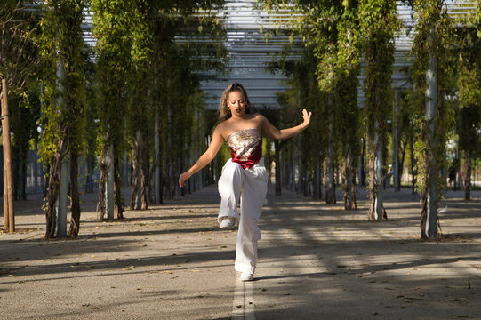 Latin and Hispanic girl, young and beautiful, dancing modern dance in the street outdoors. Dance concept, moonwalk, jumpstyle, shuffle, electrodance, hip hop, funky, popping.