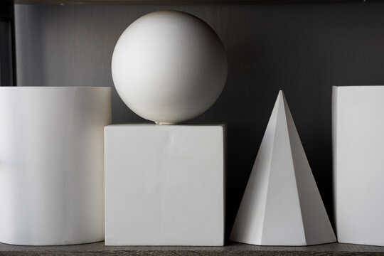three-dimensional figures of different shapes on which a soft shadow falls
