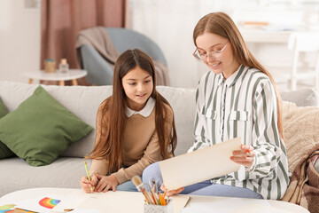 Obraz premium Drawing teacher giving private art lesson to little girl at home