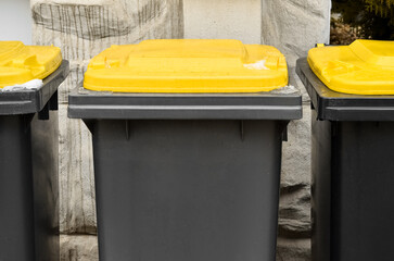 View of garbage containers in city on winter day