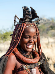 Happy Himba woman smiling, dressed in traditional style in Namibia, Africa.