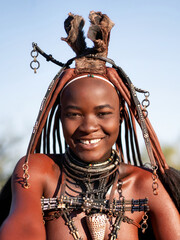 Happy Himba woman smiling, dressed in traditional style in Namibia, Africa.