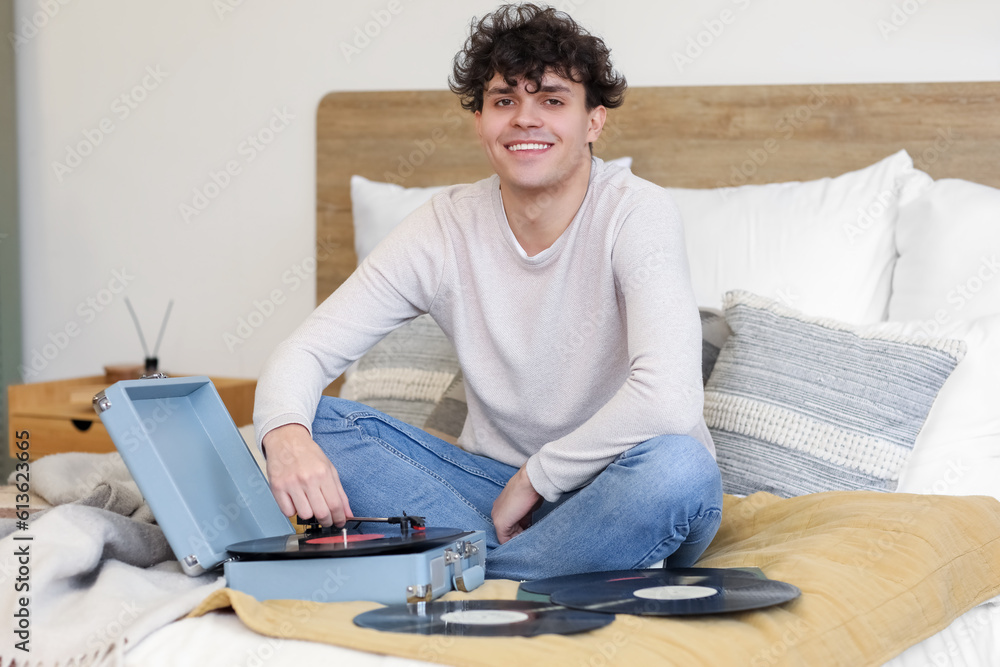 Wall mural young man with record player in bedroom