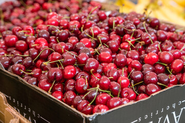 Close up of cherries on display at an outdoor farmers' market.